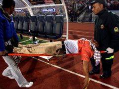 Zraněný fanoušek je odnášen na nosítkách při utkání Egypt - Alžírsko.