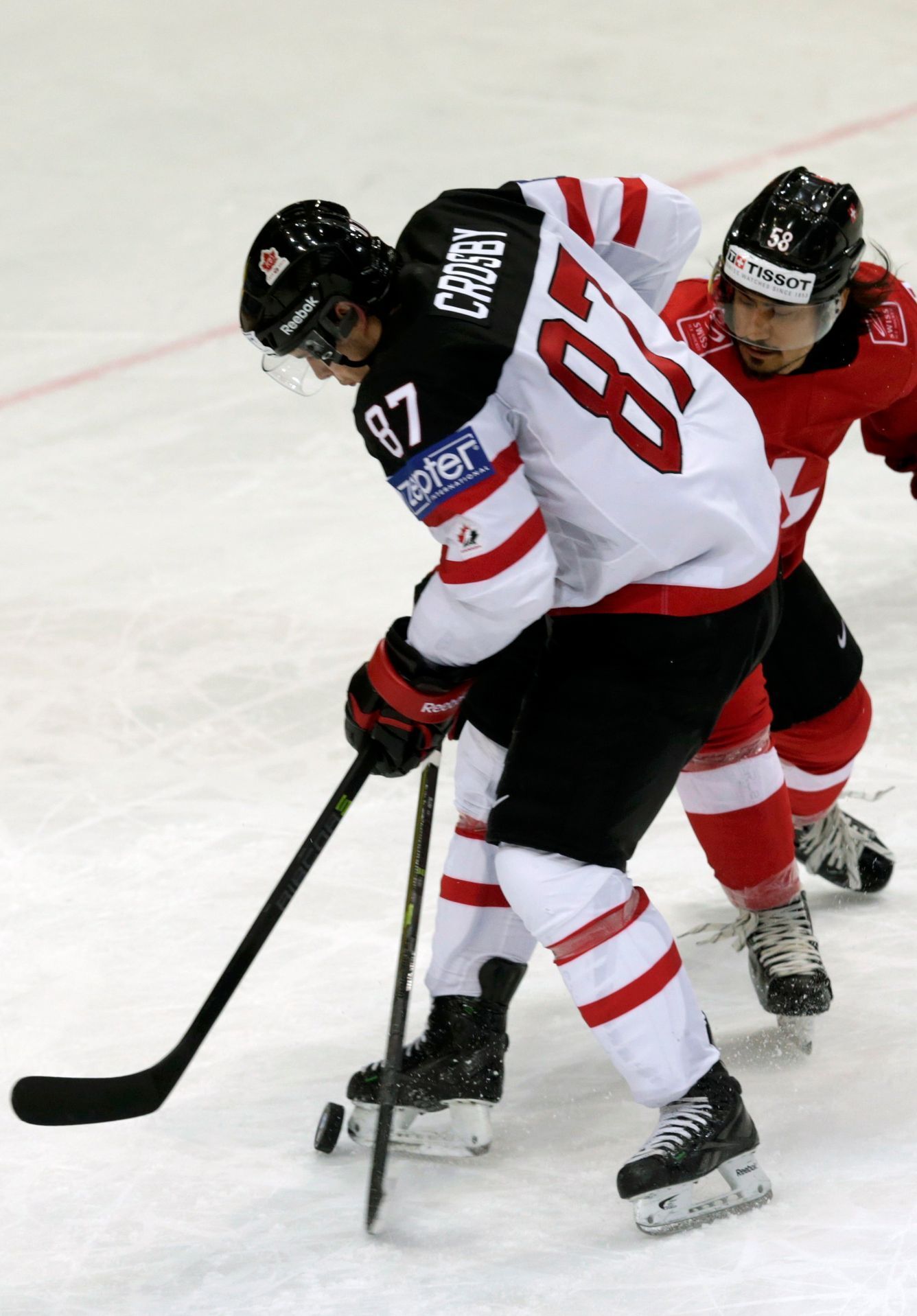 Canada's Crosby fights for the puck with Switzerland's Blum during their Ice Hockey World Championship game at the O2 arena in Prague