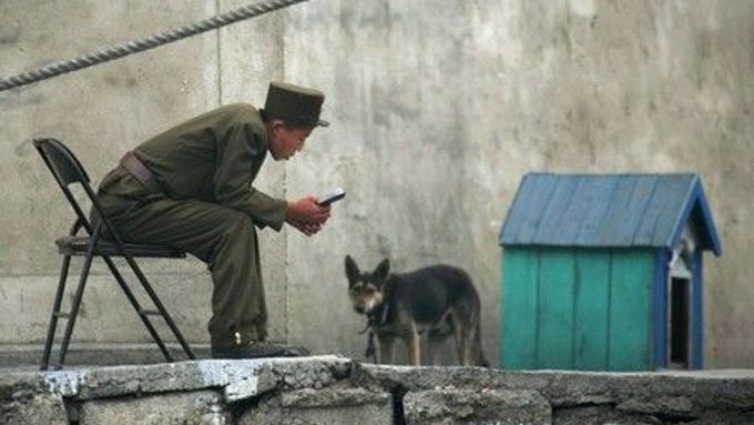 Voják se psem v severokorejské vesnici u hranice s Čínou.