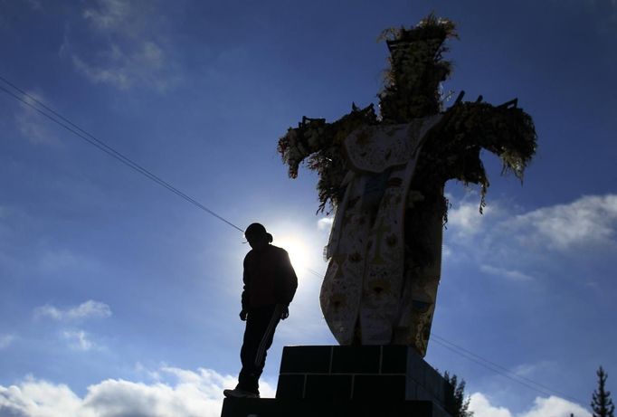 Marathon runner Gladys Tejeda, the first Peruvian athlete who qualified for the 2012 London Olympic Games, stands next to a cross before training at the San Cristobal mountain in the Andean province of Junin May 15, 2012. A private company will take Gladys' mother Marcelina Pucuhuaranga, 69, to London as part of the "Thank you Mom" program. For Pucuhuaranga, who received her first passport, it will be the first time travelling out of Peru. The program will take about 120 mothers of different athletes around the world to attend the games. Tejeda, the youngest of nine children, returned to her hometown to visit her mother and to focus on training where she will run more than 20 km every day in the highlands (over 4,105 meters above sea level). Picture taken May 15, 2012. REUTERS/Pilar Olivares(PERU - Tags: SPORT ATHLETICS OLYMPICS) Published: Kvě. 17, 2012, 6:25 odp.