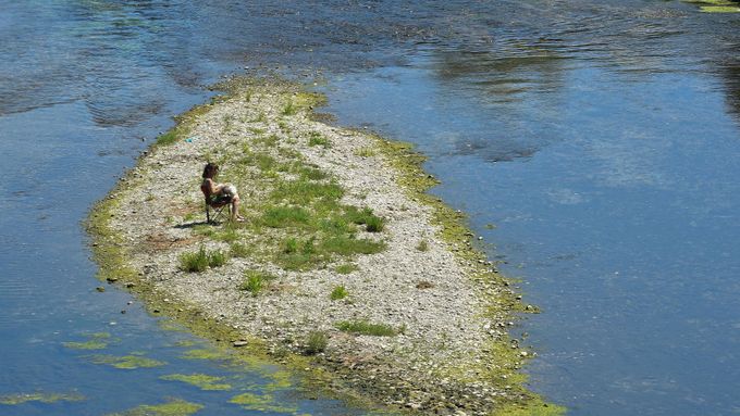 Carmagnola nedaleko města Turín v Itálii.  Žena sedí u vyschlého koryta nejdelší italské řeky Pád. Nejhorší sucho za posledních 70 let řeku osušilo.