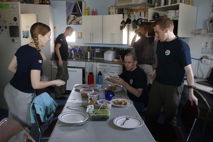 Members of Crew 125 EuroMoonMars B mission prepare a meal at the Mars Desert Research Station (MDRS) outside Hanksville in the Utah desert March 2, 2013. The MDRS aims to investigate the feasibility of a human exploration of Mars and uses the Utah desert's Mars-like terrain to simulate working conditions on the red planet. Scientists, students and enthusiasts work together developing field tactics and studying the terrain. All outdoor exploration is done wearing simulated spacesuits and carrying air supply packs and crews live together in a small communication base with limited amounts of electricity, food, oxygen and water. Everything needed to survive must be produced, fixed and replaced on site. Picture taken March 2, 2013. REUTERS/Jim Urquhart (UNITED STATES - Tags: SCIENCE TECHNOLOGY SOCIETY ENVIRONMENT) ATTENTION EDITORS: PICTURE 30 OF 31 FOR PACKAGE 'MARS IN THE DESERT' SEARCH 'JIM MARS' FOR ALL IMAGES Published: Bře. 11, 2013, 2:09 odp.