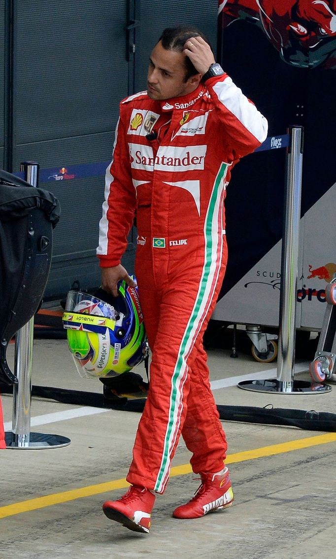 Ferrari Formula One driver Felipe Massa of Brazil returns to his pit after crashing during second practice ahead of the British Grand Prix at the Silverstone Race circuit