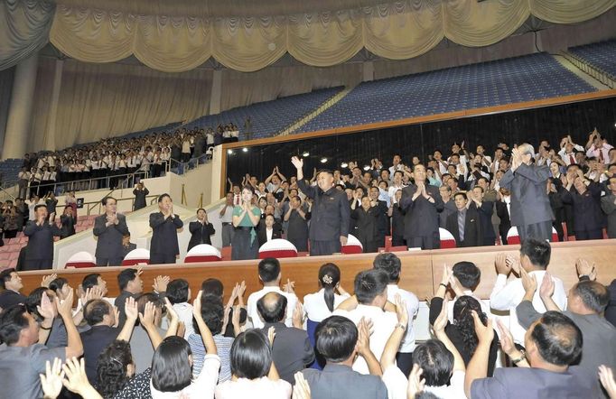 North Korean leader Kim waves next to his wife Ri as guests applaud during the 2013 Asian Cup and Interclub Junior and Senior Weightlifting Championship in Pyongyang