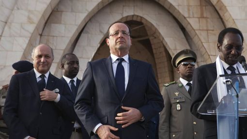 France's President Francois Hollande (C) and France's Foreign Affairs Minister Laurent Fabius (L) stand as Mali's interim president Dioncounda Traore (R) speaks to a crowd at Independence Plaza in Bamako, Mali February 2, 2013. France will withdraw its troops from Mali once the Sahel state has restored sovereignty over its national territory and a U.N.-backed African military force can take over from the French soldiers, Hollande said on Saturday. REUTERS/Joe Penney (MALI - Tags: POLITICS CONFLICT) Published: Úno. 2, 2013, 7:34 odp.