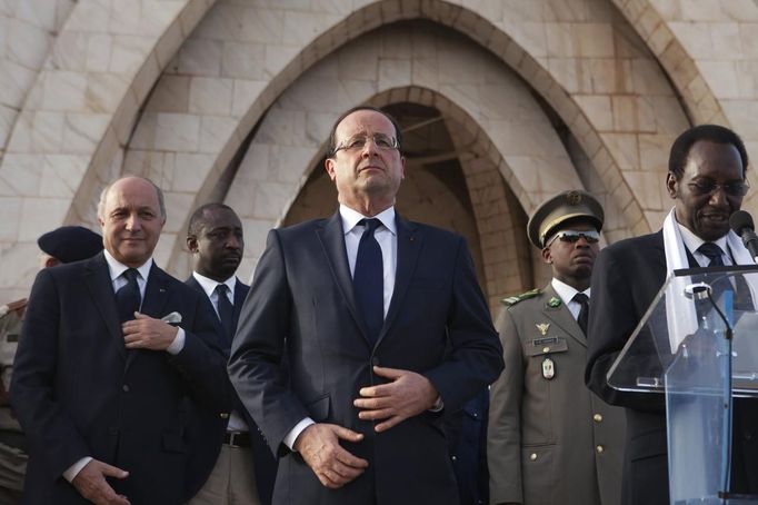 France's President Francois Hollande (C) and France's Foreign Affairs Minister Laurent Fabius (L) stand as Mali's interim president Dioncounda Traore (R) speaks to a crowd at Independence Plaza in Bamako, Mali February 2, 2013. France will withdraw its troops from Mali once the Sahel state has restored sovereignty over its national territory and a U.N.-backed African military force can take over from the French soldiers, Hollande said on Saturday. REUTERS/Joe Penney (MALI - Tags: POLITICS CONFLICT) Published: Úno. 2, 2013, 7:34 odp.