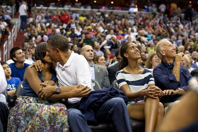 July 16, 2012 "The President and First Lady were attending the game between the U.S. Men's Olympic basketball team and Brazil in Washington, D.C. During the first half, the jumbotron flashed couples on their 'Kiss Cam', where they are then induced by the crowd to kiss each other. But neither the President or First Lady saw themselves when they were flashed on the 'Kiss Cam', and some in the audience booed when they didn't kiss. At halftime, as we walked to the locker room to visit the U.S. team, daughters Malia and Sasha were asking their parents why they hadn't kissed during their 'Kiss Cam' moment. Both the President and First Lady said they hadn't even realized what had happened and didn't know why people were booing. So in the second half, when they appeared again on the 'Kiss Cam', the President leaned over to kiss the First Lady amidst audience cheers as Malia and the Vice President watched overhead on the jumbotron."