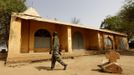 A Malian soldier walks away from a cross believed to be removed by Islamist rebels from the church seen in the background in the recently liberated town of Diabaly January 24, 2013. REUTERS/Eric Gaillard (MALI - Tags: CIVIL UNREST CONFLICT MILITARY RELIGION POLITICS) Published: Led. 24, 2013, 6:07 odp.