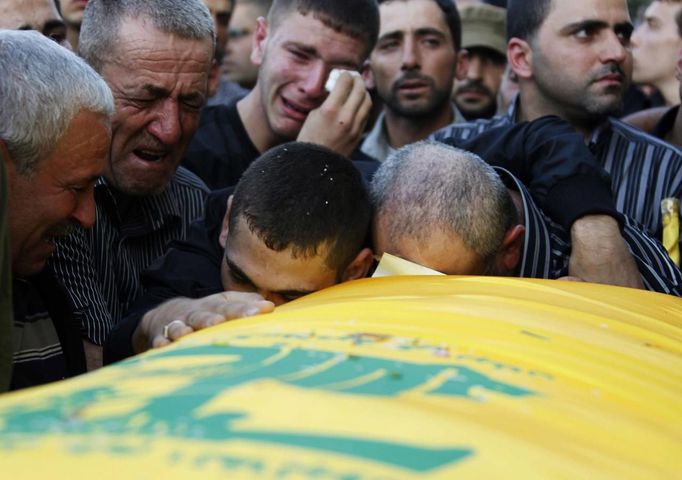 RNPS IMAGES OF THE YEAR 2012 - Relatives mourn over the coffin of a Hezbollah member during his funeral in Sehmor village, in West Bekaa October 4, 2012. Three members of the Shi'ite Muslim militant group Hezbollah were killed on Wednesday when an explosion ripped through a weapons warehouse in eastern Lebanon, the group said. REUTERS/Mohamed Azakir (LEBANON - Tags: POLITICS CIVIL UNREST) Published: Pro. 4, 2012, 1:08 dop.