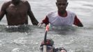 Papuan villagers watch Frenchman Philippe Croizon swim to the shore in the coastal village of Pasar Skow located in Indonesia's eastern province of Papua on May 17, 2012. Croizon, 43, who lost his limbs in an accident braved strong winds and currents to swim from Papua New Guinea to Indonesia on May 17, in the first stretch of a mission to swim between five continents. Croizon, who uses prosthetic limbs with flippers attached took seven and a half hours for the 20 kilometre (12-mile) journey.