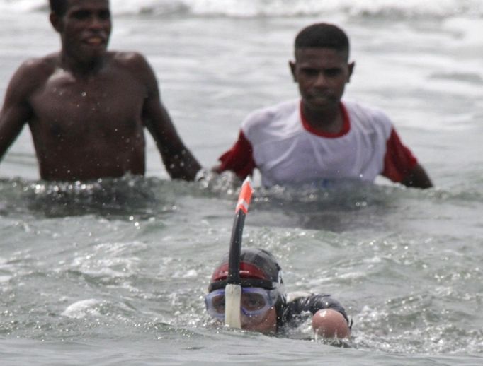 Papuan villagers watch Frenchman Philippe Croizon swim to the shore in the coastal village of Pasar Skow located in Indonesia's eastern province of Papua on May 17, 2012. Croizon, 43, who lost his limbs in an accident braved strong winds and currents to swim from Papua New Guinea to Indonesia on May 17, in the first stretch of a mission to swim between five continents. Croizon, who uses prosthetic limbs with flippers attached took seven and a half hours for the 20 kilometre (12-mile) journey.