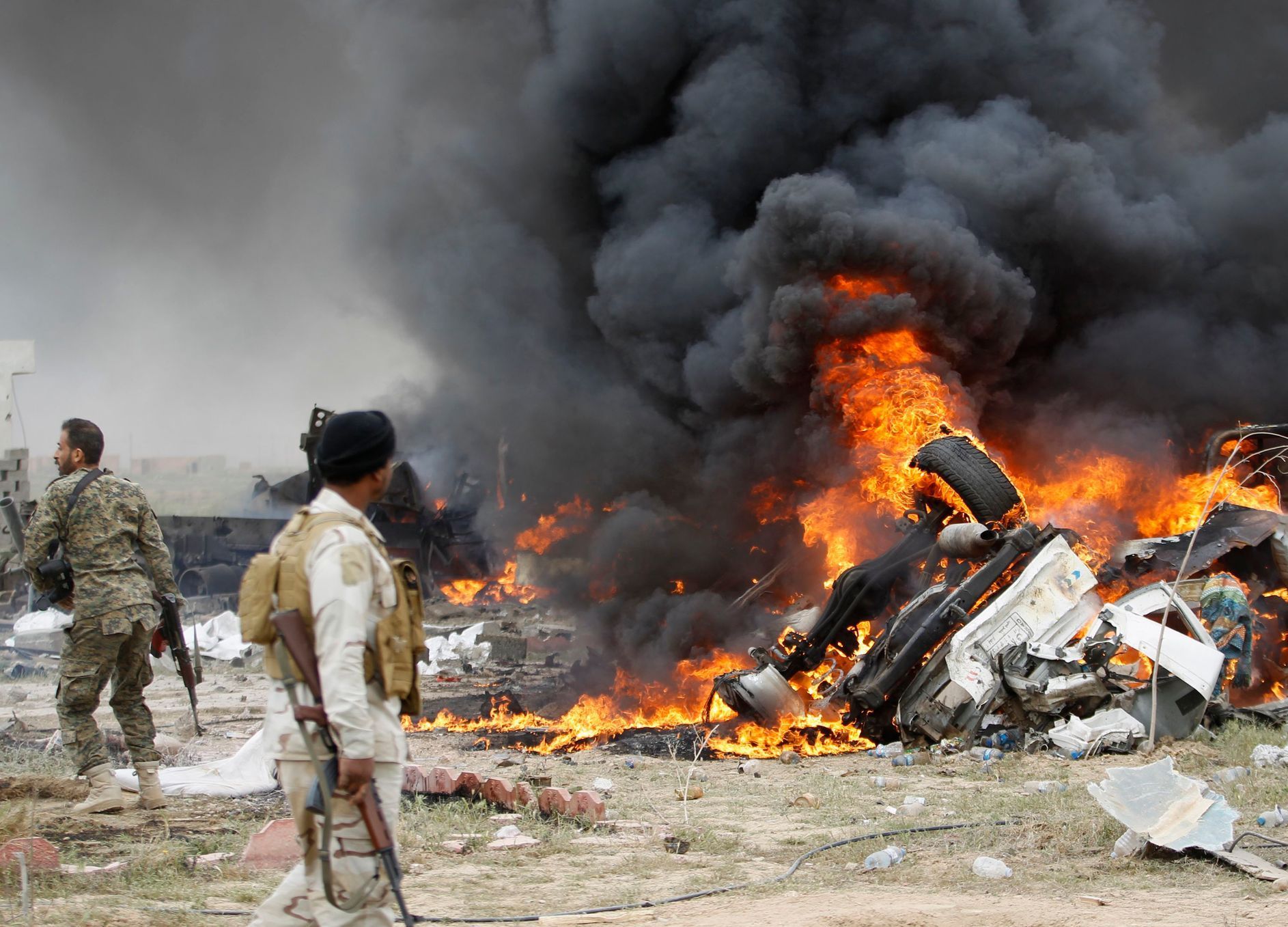 Příslušníci iráckých šíitských milic kolem automobilu se sebevražedným atentátníkem Islámského státu.