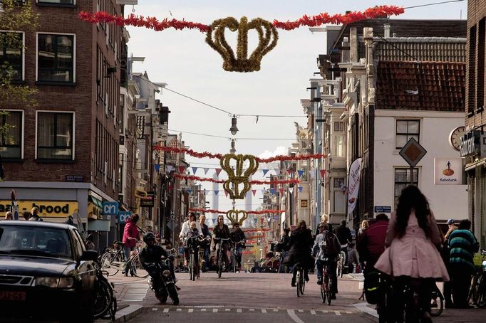 A street is decorated with golden crowns and red, white and blue banners in the city centre in Amsterdam April 24, 2013. The Netherlands is preparing for Queen's Day on April 30, which will also mark the abdication of Queen Beatrix and the investiture of her eldest son Willem-Alexander. REUTERS/Cris Toala Olivares (NETHERLANDS - Tags: ROYALS POLITICS TRAVEL TRANSPORT) Published: Dub. 24, 2013, 7:55 odp.