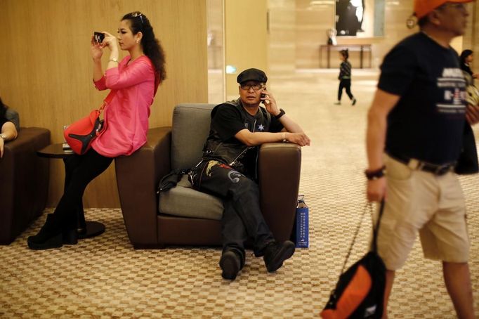 A Harley Davidson rider talks on the phone at a hotel during the annual Harley Davidson National Rally in Qian Dao Lake, in Zhejiang Province May 11, 2013. Around 1,000 Harley Davidson enthusiasts from all over China met to celebrate the 5th Harley Davidson National Rally in China, as part of the company's 110-year anniversary. Major Chinese cities ban motorcycles from circulating on highways and major avenues. Meanwhile, Harley Davidson motorbikes are considered by Chinese tax authorities to be luxury items, so they are taxed at extremely high rates-- sometimes the taxes alone is equivalent to the bike's U.S. price tag. Traffic and transportation authorities have also weighed in, putting Harleys in the same category as electric bikes, horses and bicycles, meaning that they cannot be on highways and major avenues. Picture taken May 11, 2013. REUTERS/Carlos Barria (CHINA - Tags: TRANSPORT SOCIETY) Published: Kvě. 13, 2013, 11:04 odp.