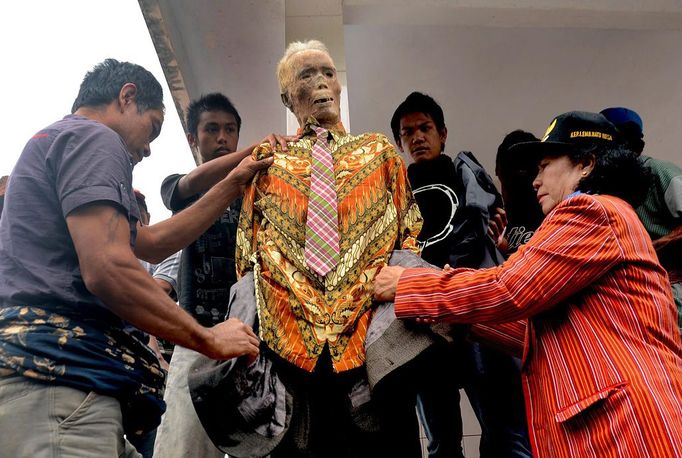 popis: Mummy Ma'nene Ritual 2012-08-23 00:00:00 epa03368998 A picture made available on 24 August 2012 shows relatives putting on clothes on a mummy of Piter Sampe Sambara (C) who died 80 years ago during Ma'nene ritual in Rinding Allo, Toraja district, South Sulawesi province Indonesia, 23 August 2012. Relatives changed the clothes of the mummy as a show of love to their ancestors. EPA/ANDI SAMUDRA