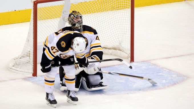Hokejisté Bostonu Torey Krug a Jaroslav Halák vstřebávají konec po trefě v prodloužení.