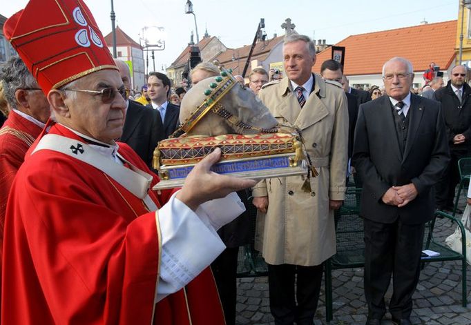 Lebka vládce minulosti míjí stojící vládce současnosti (premiér Topolánek a prezident Klaus).