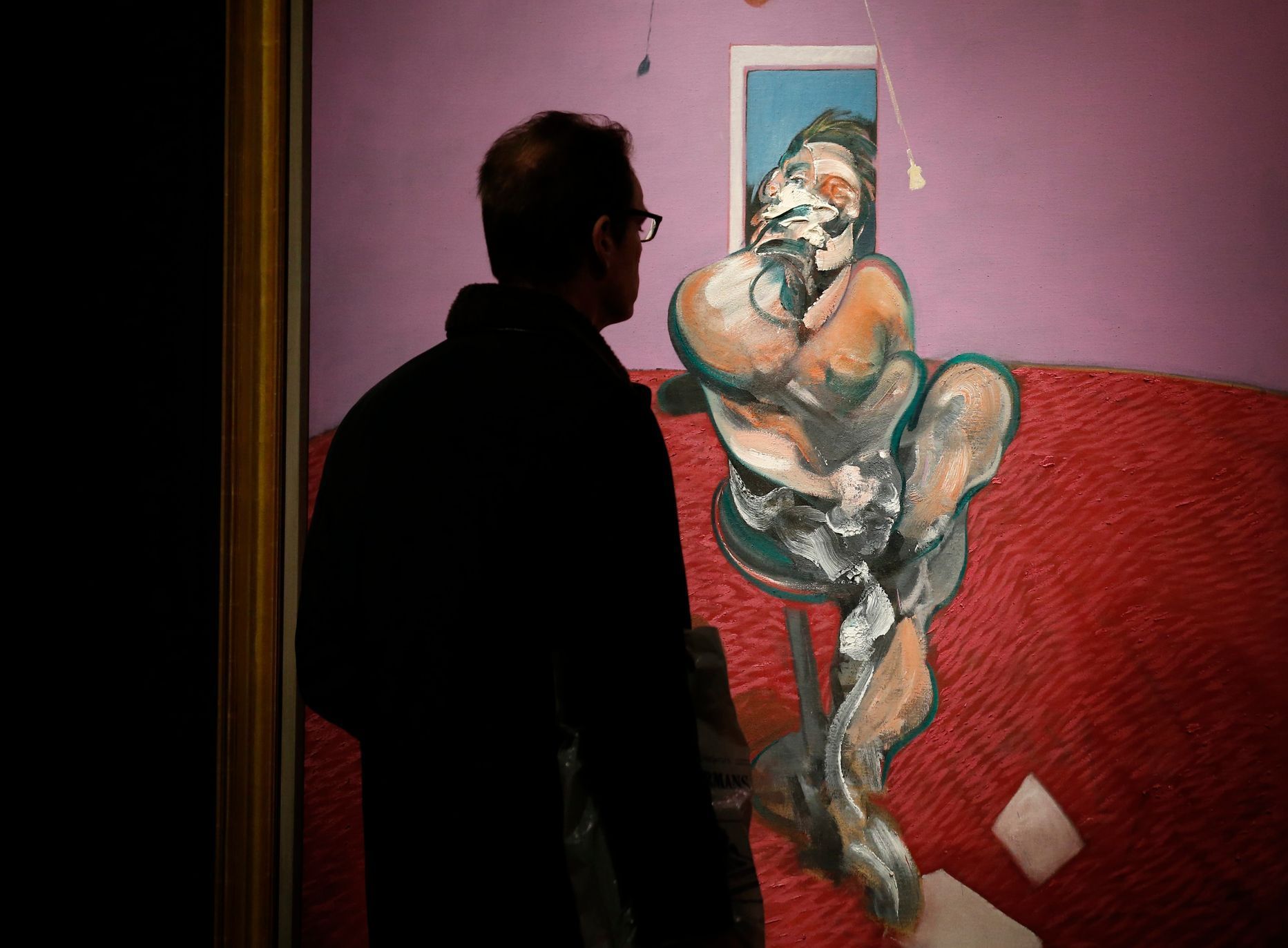 A visitor looks at &quot;Portrait of George Dyer Talking&quot; by Francis Bacon in 1966 on display at Christie's in London