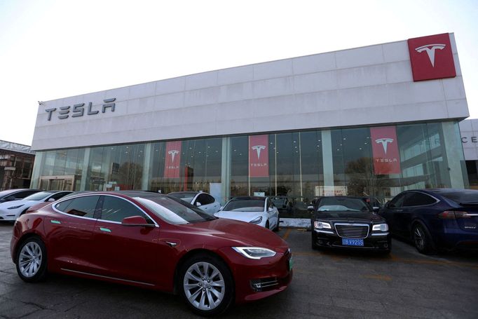 FILE PHOTO: A Tesla car is driven past a store of the electric vehicle (EV) maker in Beijing, China January 4, 2024. REUTERS/Florence Lo/File Photo