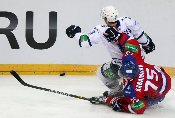 Hokejista Dynama Moskva je držen Vitalijem Karamnovem v utkání KHL 2012/13 proti Lvu Praha.