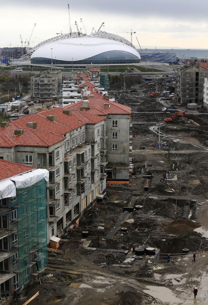 A general view shows the construction site of the Olympic athletes village in front of the Olympic Park with the Olympic stadium for the Sochi 2014 Winter Olympics in Adler, near Sochi February 18, 2013. Although many complexes and venues in the Black Sea resort of Sochi mostly resemble building sites that are still under construction, there is nothing to suggest any concern over readiness. Construction will be completed by August 2013 according to organizers. The Sochi 2014 Winter Olympics opens on February 7, 2014. REUTERS/Kai Pfaffenbach (RUSSIA - Tags: BUSINESS CONSTRUCTION ENVIRONMENT SPORT OLYMPICS) Published: Úno. 18, 2013, 6:42 odp.