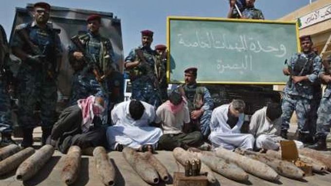 Iráčtí vojáci pózují fotografům se skupinou zadržených povstalců a zabavenými zbraněmi.