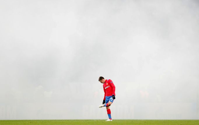 Fotbalista CSKA Moskva Georgij Ščenikov za kouřovou clonou vytvořenou fanoušky na stadionu v Lužnikách.