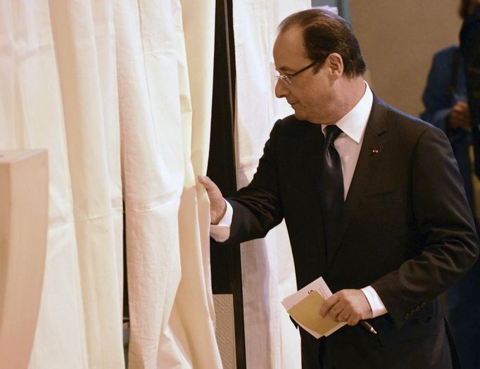 Francouzký prezident Francois Hollande vstupuje za plentu ve volební místnosti v Tulle.