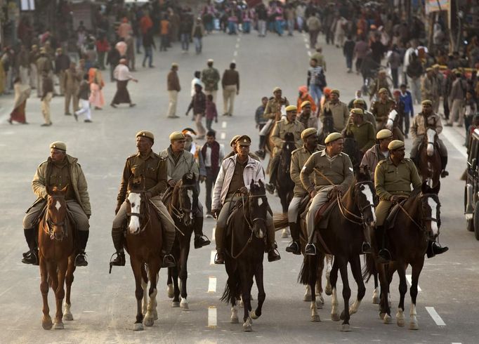 Indian policemen mounted on their horses clear the way for a religious procession near the banks of the river Ganges ahead of the "Kumbh Mela" (Pitcher Festival) in the northern Indian city of Allahabad January 11, 2013. During the festival, Hindus take part in a religious gathering on the banks of the river Ganges. "Kumbh Mela" will return to Allahabad in 12 years. REUTERS/Ahmad Masood (INDIA - Tags: RELIGION SOCIETY ANIMALS) Published: Led. 11, 2013, 6:34 odp