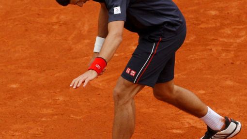 Novak Djokovič mrštil vzteky s raketou během finále French Open 2012.
