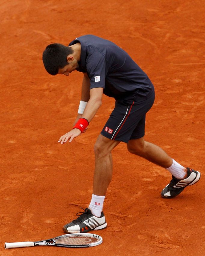 Novak Djokovič mrštil vzteky s raketou během finále French Open 2012.