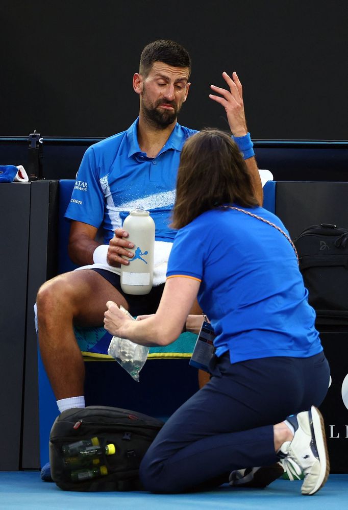 Ošetřovaný Novak Djokovič v zápase 3. kola Australian Open s Tomášem Macháčem