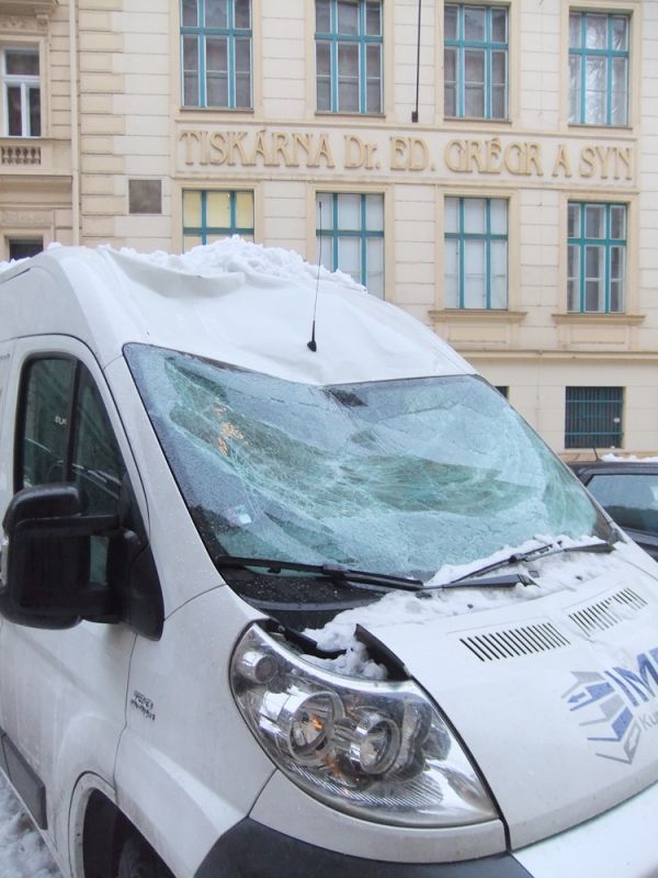 Auta poničená sněhem v pražské Hálkově ulici.