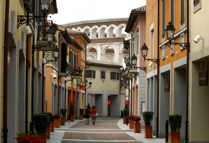 Pedestrians walk down an alley that resembles a Florentine-style street towards a building that looks like a Roman Coliseumin the Florentia Village in the district of Wuqing, located on the outskirts of the city of Tianjin June 13, 2012. The shopping center, which covers an area of some 200,000 square meters, was constructed on a former corn field at an estimated cost of US$220 million, and copies old Italian-style architecture with Florentine arcades, a grand canal, bridges, and a Coliseum-like building. REUTERS/David Gray (CHINA - Tags: SOCIETY BUSINESS) Published: Čer. 13, 2012, 5:36 odp.