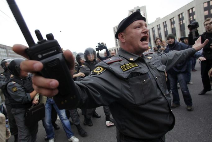 Policista se snaží urovnat potyčky mezi nacionalisty a antifašisty během protestů v Moskvě