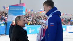 Prezident Vladimir Putin gratuluje na univerziádě v Krasnojarsku při slavnostním ceremoniálu po závodě běžců na 10 kilometrů ruským sportovcům, kteří obsadili všechna tři místa na stupních vítězů...