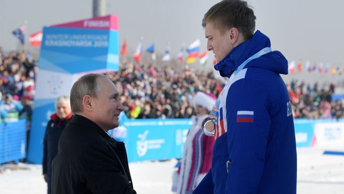 Prezident Vladimir Putin gratuluje na univerziádě při ceremoniálu po závodě běžců na 10 kilometrů ruským sportovcům, kteří obsadili všechna tři místa na stupních vítězů
