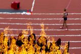 Záběr na olympijský oheň při závodě ženských sedmibojařek.