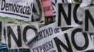 A riot police officer stands behind placards placed on barriers that cordon off the Spanish parliament in Madrid, September 25, 2012. Protesters clashed with police in Spain's capital on Tuesday as the government prepares a new round of unpopular austerity measures for the 2013 budget that will be announced on Thursday. REUTERS/Susana Vera (SPAIN - Tags: CIVIL UNREST POLITICS BUSINESS) Published: Zář. 25, 2012, 9:11 odp.