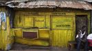 Painted wood and metal brighten recreation kiosk attached to traditional colonial-era Board House in Freetown