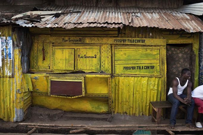 Painted wood and metal brighten recreation kiosk attached to traditional colonial-era Board House in Freetown