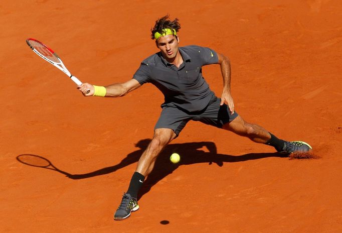 Švýcarský tenista Roger Federer odpaluje míček na Srba Novaka Djokoviče během semifinále French Open 2012.