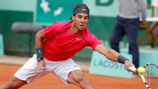 Španělský tenista Rafael Nadal se natahuje po míčku od Srba Novaka Djokoviče během finále French Open 2012.