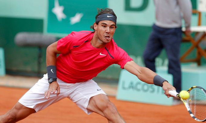 Španělský tenista Rafael Nadal se natahuje po míčku od Srba Novaka Djokoviče během finále French Open 2012.