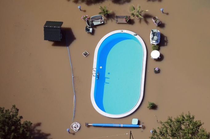 A garden with a swimming pool is inundated by the waters of the Elbe river during floods near Magdeburg in the federal state of Saxony Anhalt, June 10, 2013. Tens of thousands of Germans, Hungarians and Czechs were evacuated from their homes on Wednesday as soldiers raced to pile up sandbags to hold back rising waters in the region's worst floods in a decade. REUTERS/Thomas Peter (GERMANY - Tags: DISASTER ENVIRONMENT TPX IMAGES OF THE DAY)