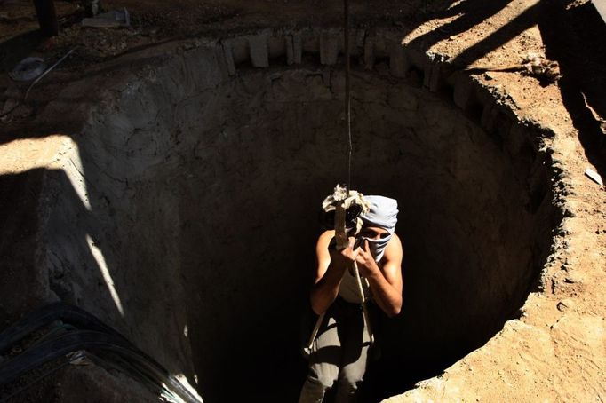 2 Titulek: Gaza's tunnel mugglers on Egypt border mostly idle Popis: A Palestinian tunnel-digger lowers himself into the smuggling tunnel beneath the Egyptian-Gaza border in Rafah in the southern Gaza, October 8, 2013. Gaza's tunnel smugglers along the border with Egypt are mostly idle these days. Since the summer, Egypt's military has tried to destroy or seal off most of the smuggling tunnels under the Gaza-Egypt border, a consequence of the heightened tensions between Cairo and the Hamas government in Gaza which is suffering a bad economic recession.