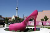 Barbie-dům stojí nedaleko berlínského televizního vysílače na Alexanderplatzu. V popředí symbol Barbie-kultu, gigantická růžová bota na podpatku.