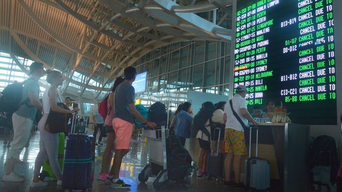 Lidé na letišti na Bali kontrolují, které lety se musely zrušit kvůli erupci sopky Mount Agung.