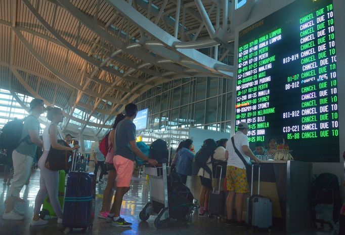 Lidé na letišti na Bali kontrolují, které lety se musely zrušit kvůli erupci sopky Mount Agung.