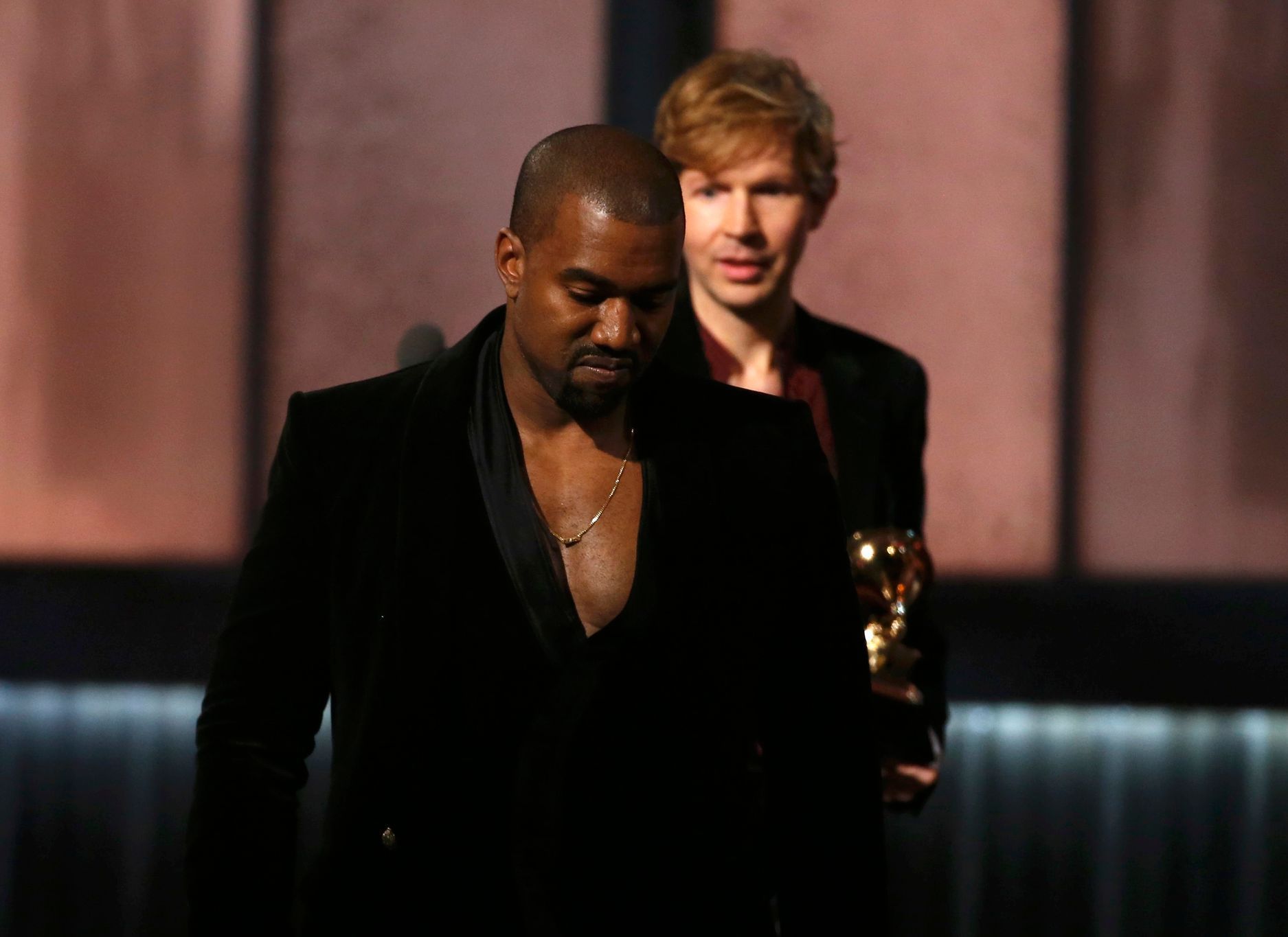Beck watches Kanye West after Beck won album of the year for &quot;Morning Phase,&quot; at the 57th annual Grammy Awards in Los Angeles